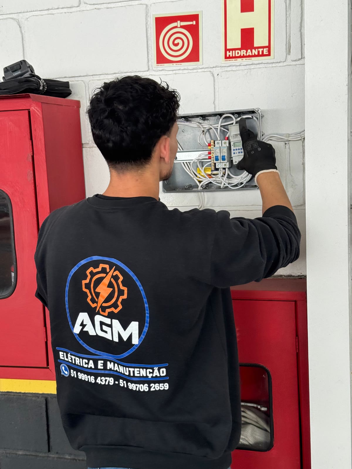 Profissional da AGM realizando trabalho em instalação elétrica